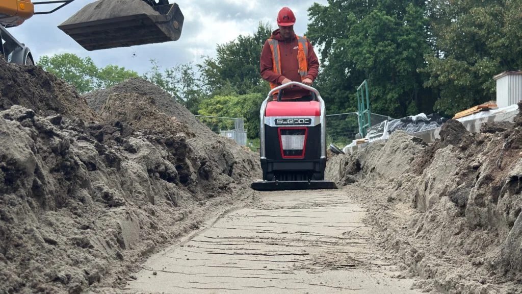 Trilplaat aan het werk tussen grondwallen