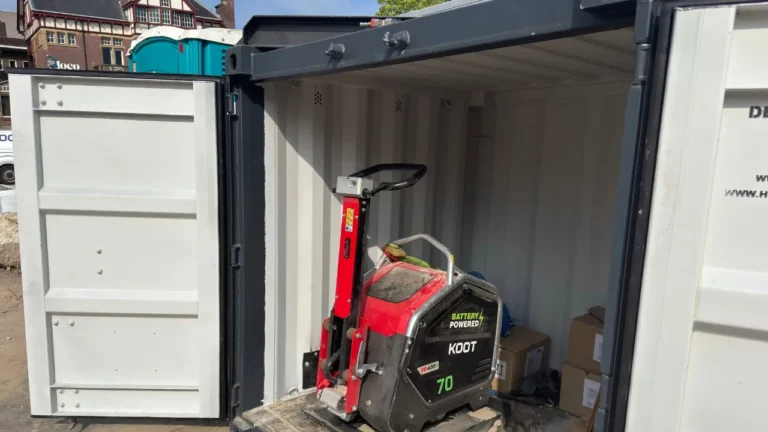 stratenmaker met zware accu trilplaat verdicht nieuwe straat tussen betonklinkers